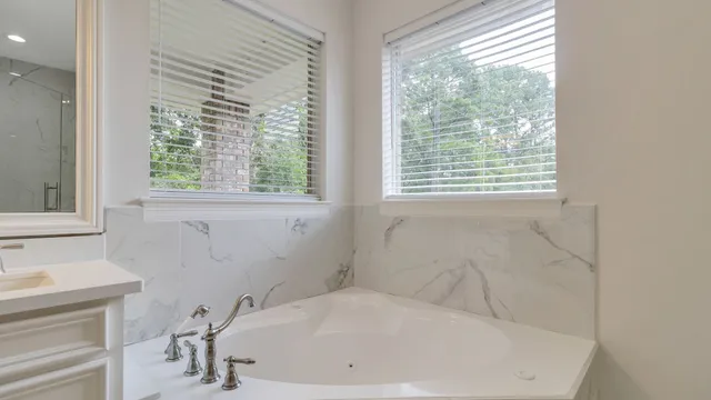a white bath tub sitting in a bathroom next to a window