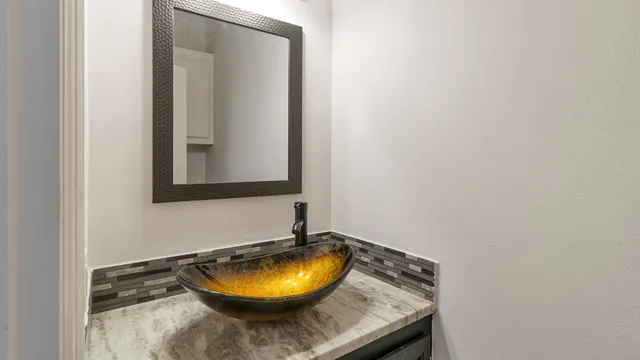 a bathroom with a granite countertop sink and mirror