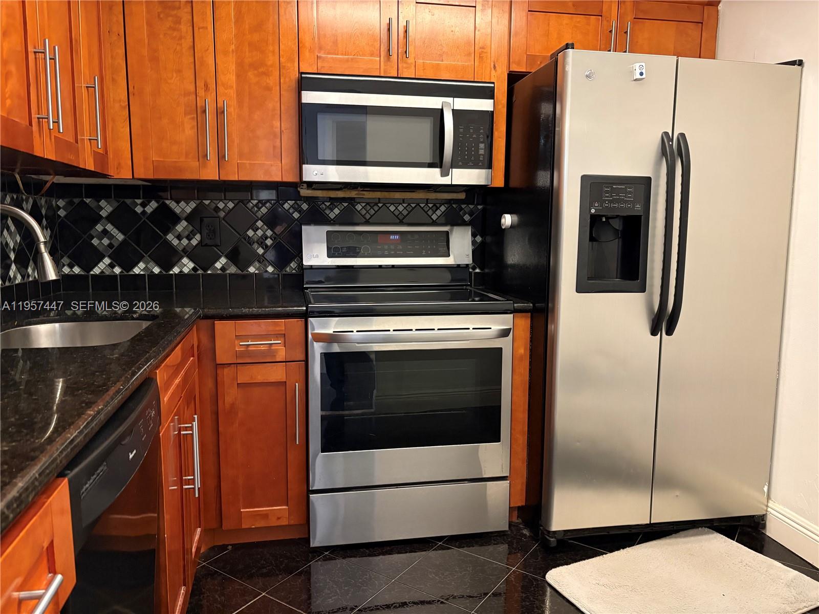 6600 Cypress Road, Unit 203 Plantation, FL 33317 - Photo 4 of 12 a kitchen with stainless steel appliances granite countertop a refrigerator and a stove top oven