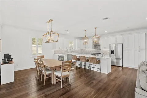 a view of a dining room with furniture a chandelier and wooden floor