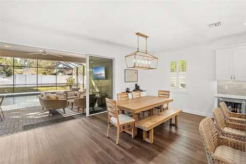 a living room with furniture a dining table and a chandelier
