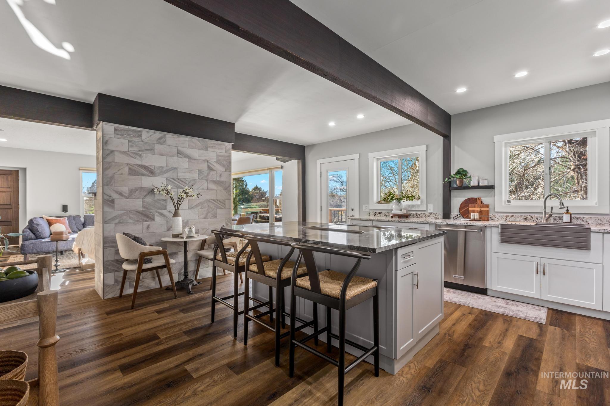 300 West Ofarrell Street Boise, ID 83702 - Photo 18 of 50 Kitchen featuring light stone countertops, a kitchen island, beam ceiling, stainless steel dishwasher, and a breakfast bar area