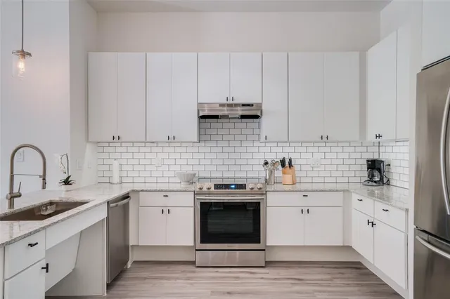 a kitchen with white cabinets stainless steel appliances and sink