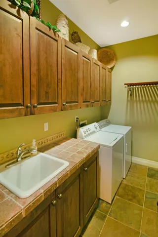a utility room with a sink and cabinets