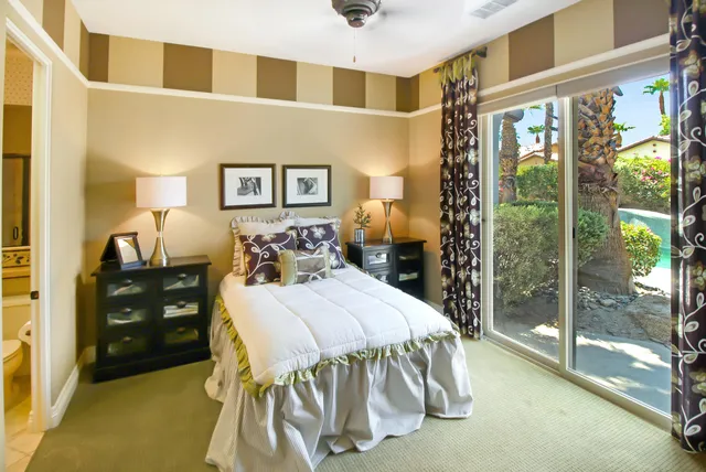 a bedroom with a bed and large window with balcony view