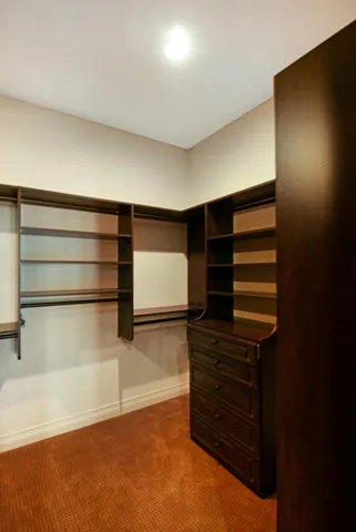 a view of walk in closet with empty racks