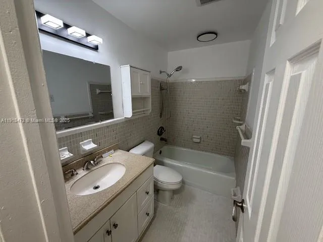 a bathroom with a sink a toilet a mirror and shower
