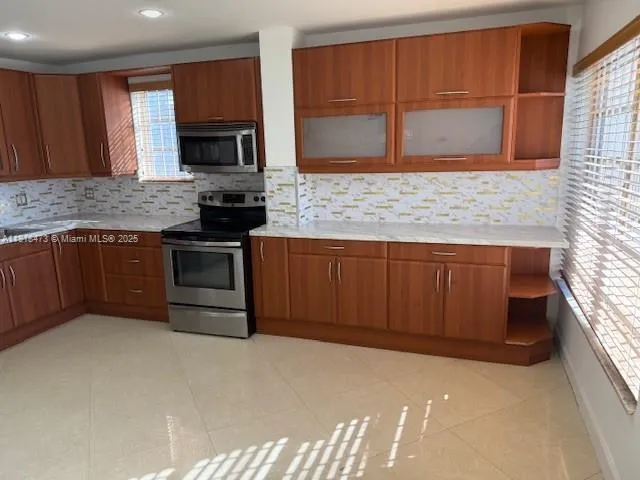 a kitchen with stainless steel appliances granite countertop a stove a sink and a microwave