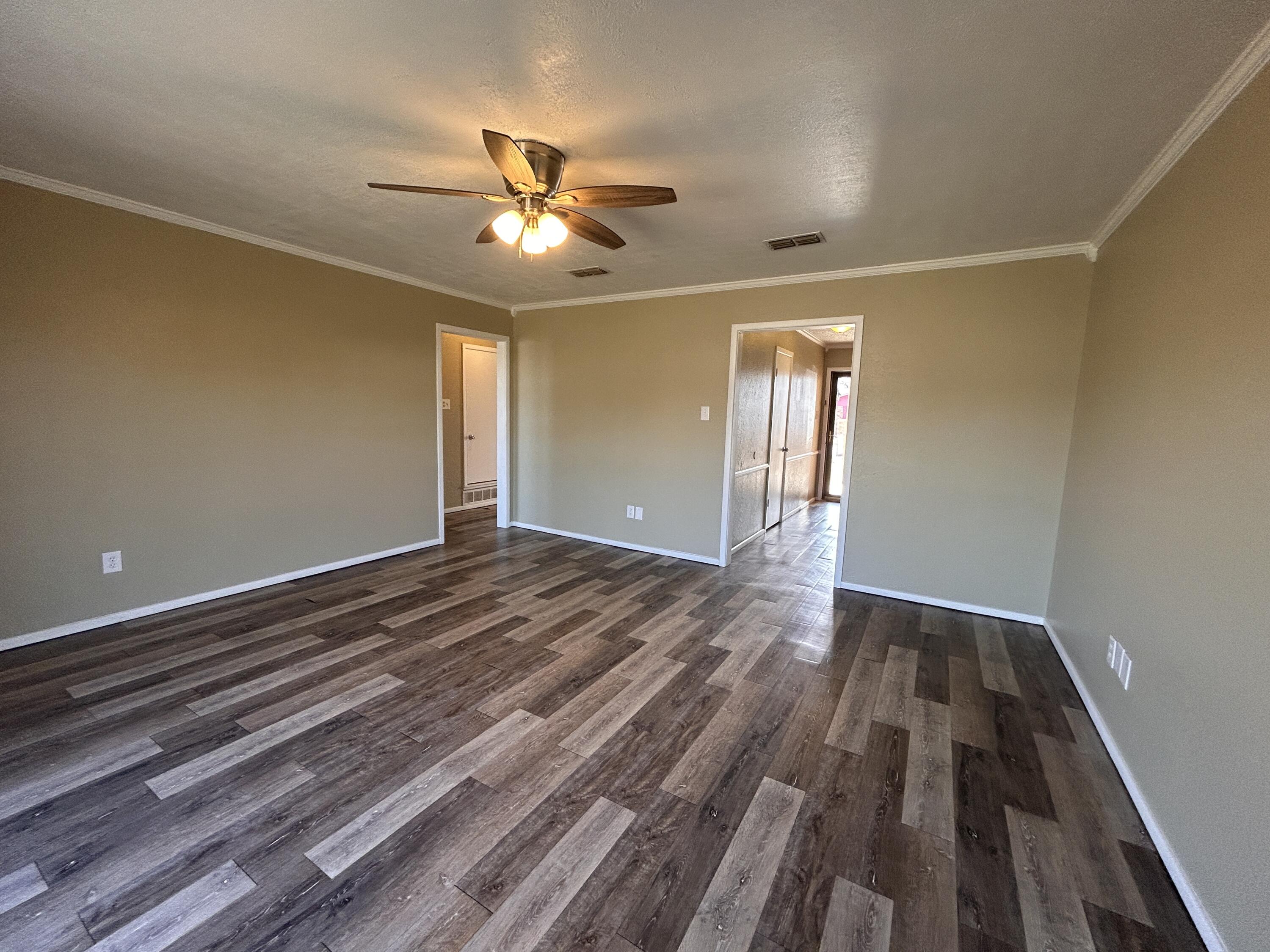 6508 25th Street Lubbock, TX 79407 - Photo 2 of 14 a view of empty room with wooden floor and fan