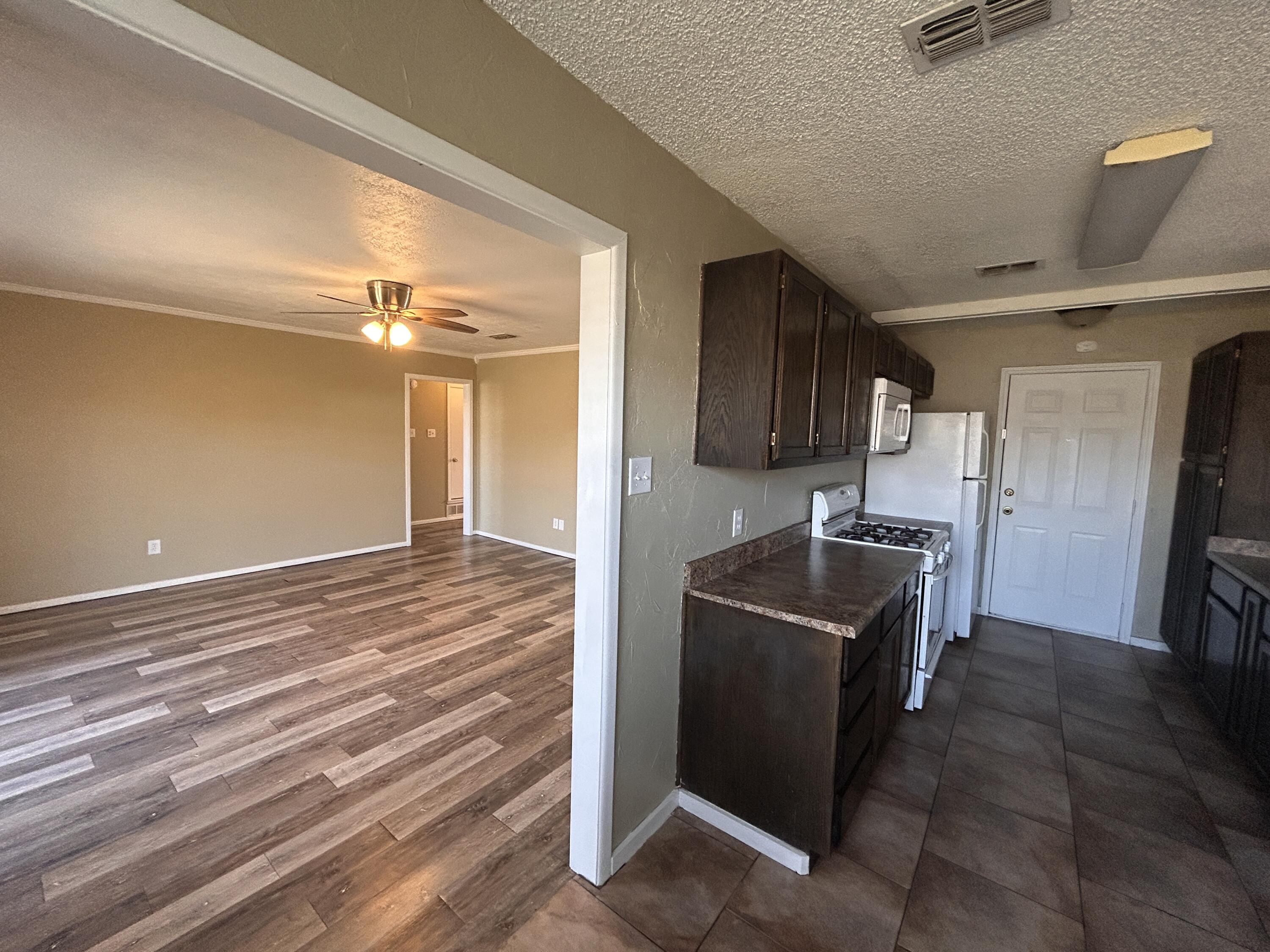 6508 25th Street Lubbock, TX 79407 - Photo 4 of 14 a kitchen with granite countertop a refrigerator and a stove