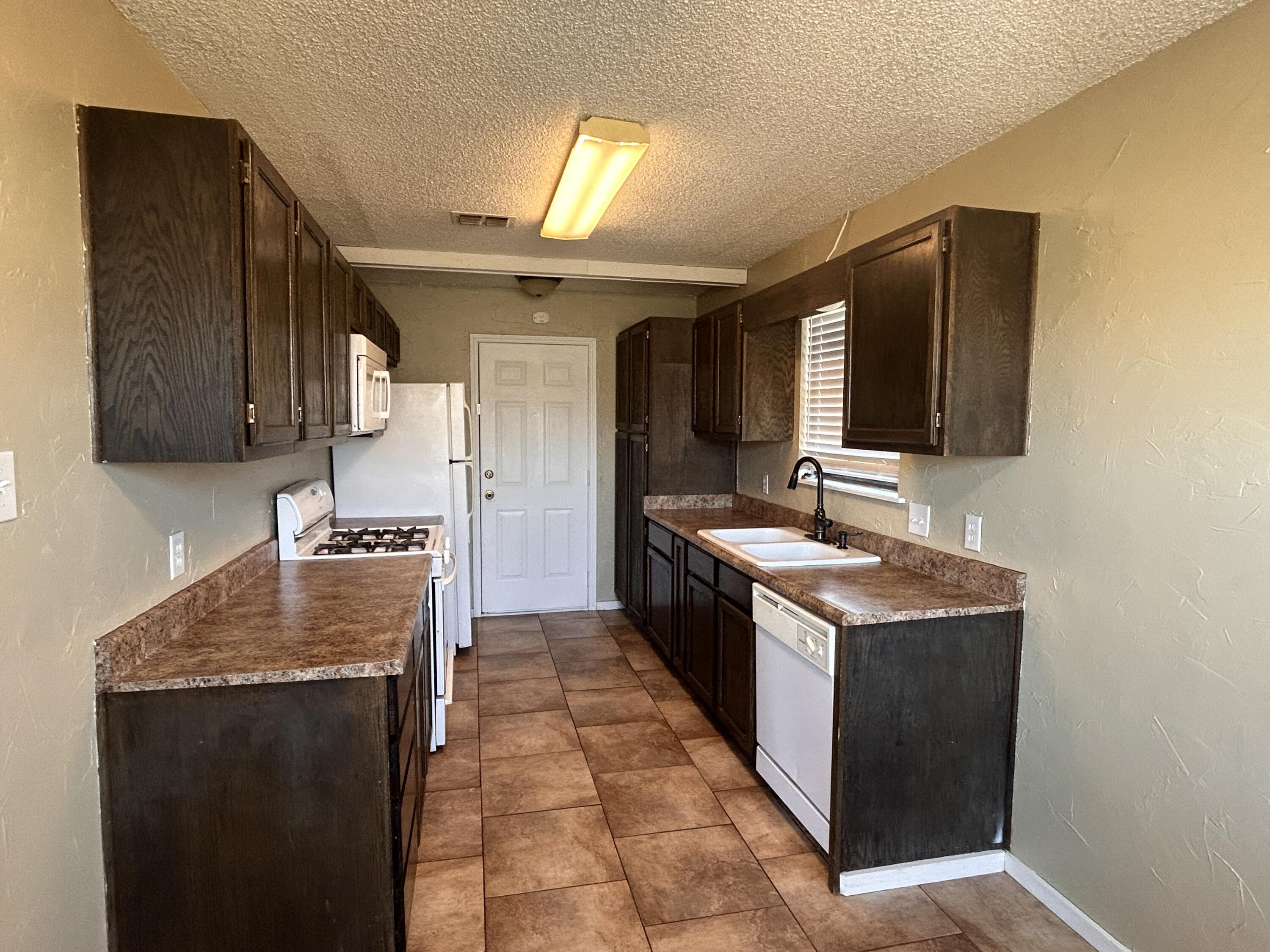 6508 25th Street Lubbock, TX 79407 - Photo 5 of 14 a kitchen with a sink stove and cabinets