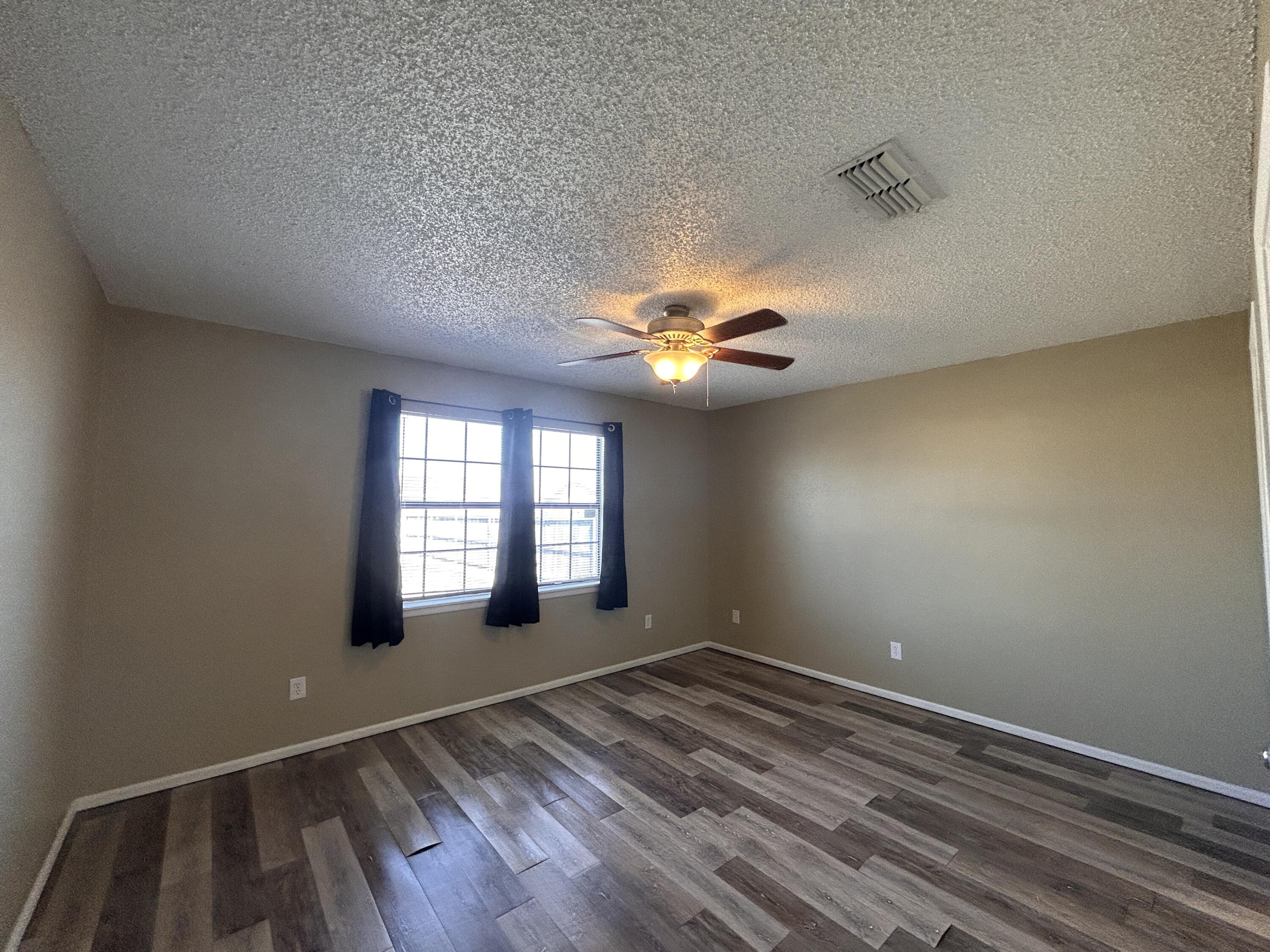 6508 25th Street Lubbock, TX 79407 - Photo 7 of 14 wooden floor in an empty room with a window