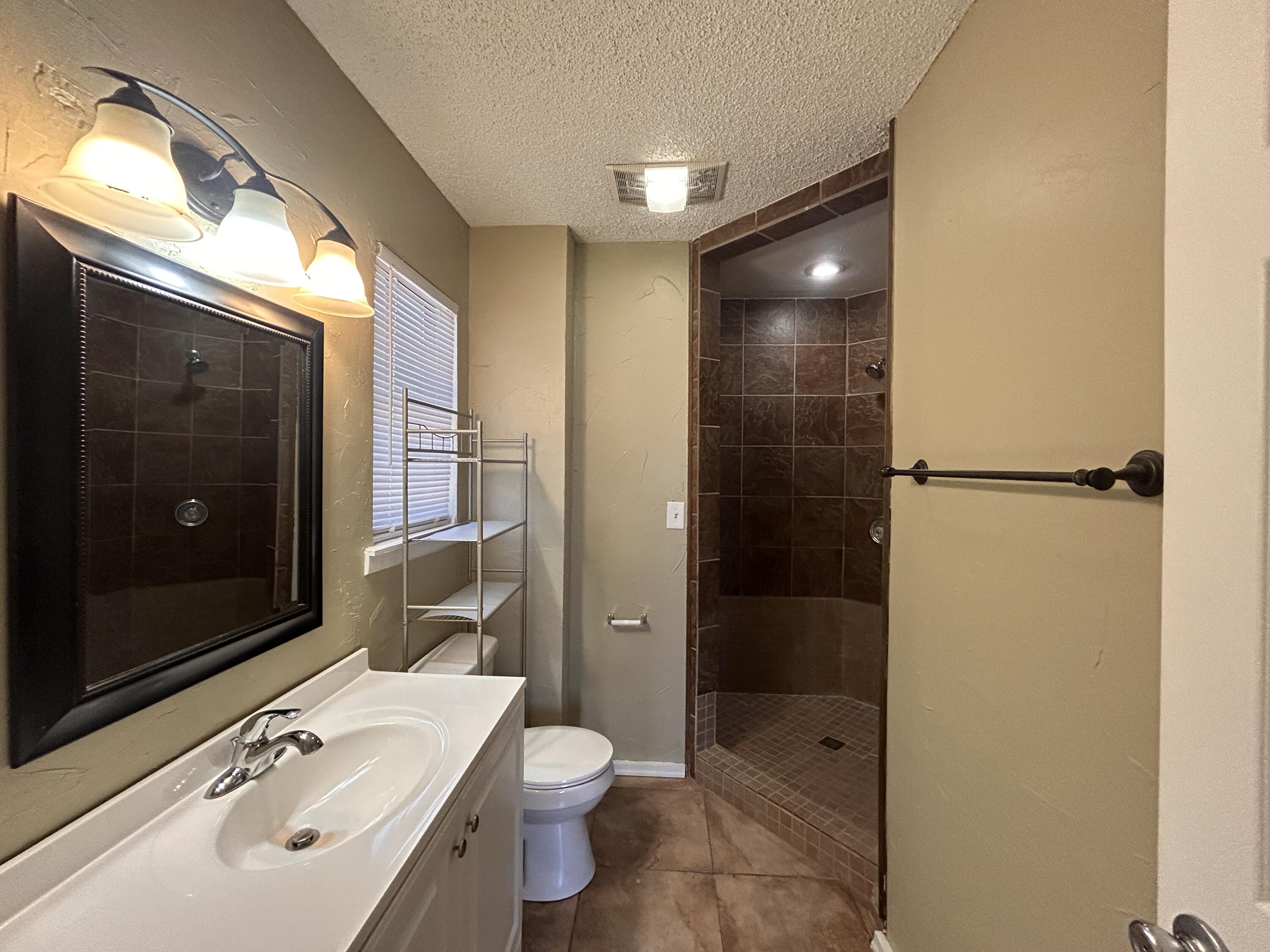 6508 25th Street Lubbock, TX 79407 - Photo 8 of 14 a bathroom with a sink a toilet and shower