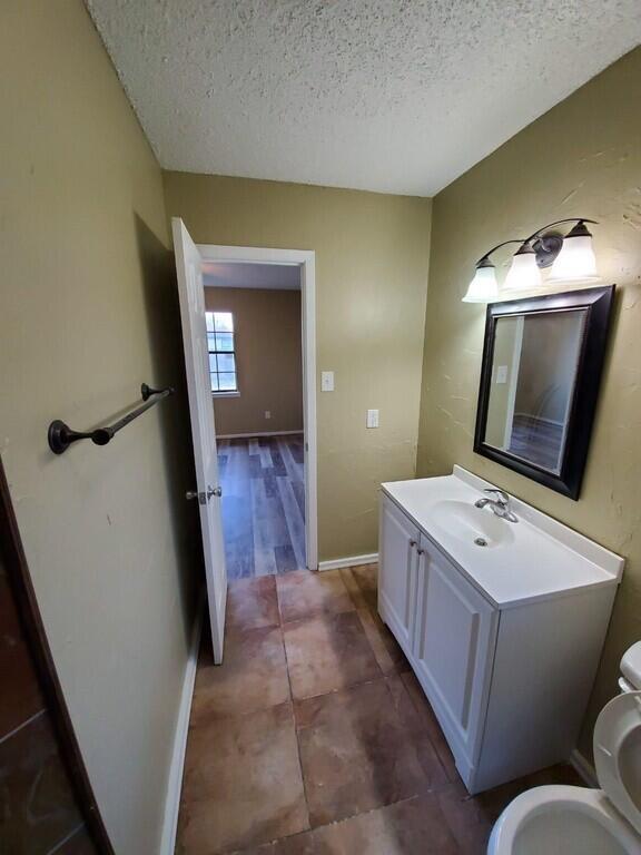 6508 25th Street Lubbock, TX 79407 - Photo 10 of 14 a bathroom with a toilet sink and mirror