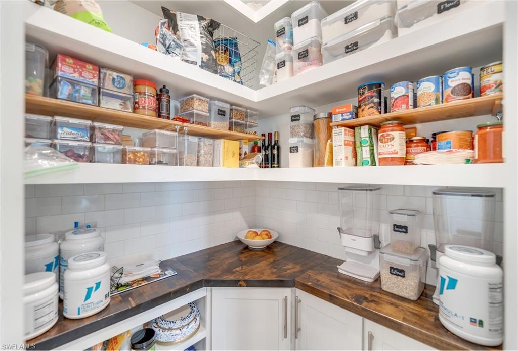 19812 Beechcrest Place Estero, FL 33928 - Photo 13 of 50 a kitchen with stainless steel appliances lots of clutter and cabinets