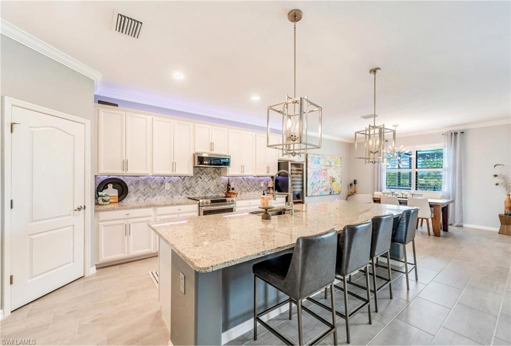 19812 Beechcrest Place Estero, FL 33928 - Photo 10 of 50 a kitchen with appliances a counter space and a center island
