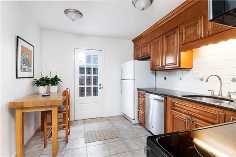 a kitchen with stainless steel appliances granite countertop a sink a stove and a refrigerator