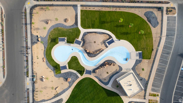 2133 Wolverine Way, Unit 2440 Washington, UT 84780 - Photo 33 of 39 Community splash pad and green spaces featuring a winding water channel, multiple shaded seating areas, extensive manicured lawns, and decorative rock landscaping