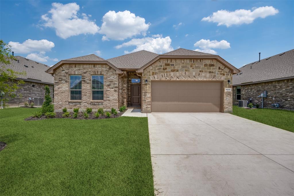 Brick and stone facade residence featuring a covered entry, an attached two-car garage, and a concrete driveway