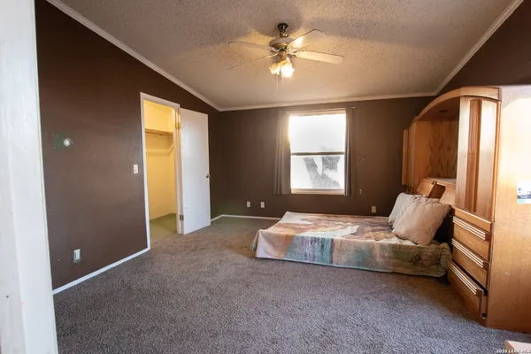 a spacious bedroom with a bed and a chandelier