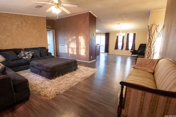 a kitchen with stainless steel appliances kitchen island granite countertop a refrigerator a stove and a wooden floors