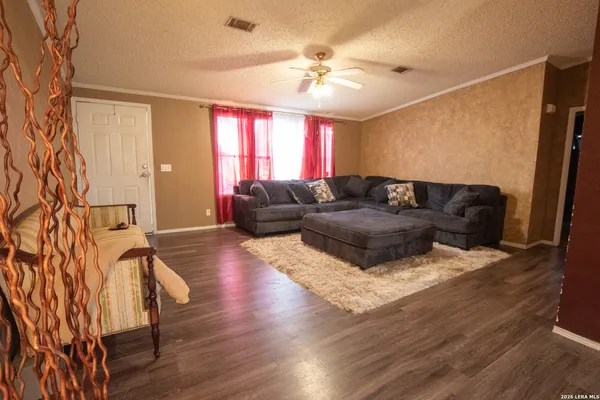 a kitchen with stainless steel appliances granite countertop a refrigerator a sink dishwasher a stove and white countertops with wooden floor