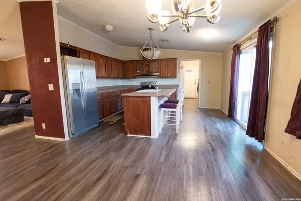 a kitchen with stainless steel appliances a stove a sink a refrigerator and wooden floor