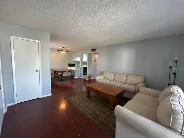 a living room with furniture and a dining table with kitchen view
