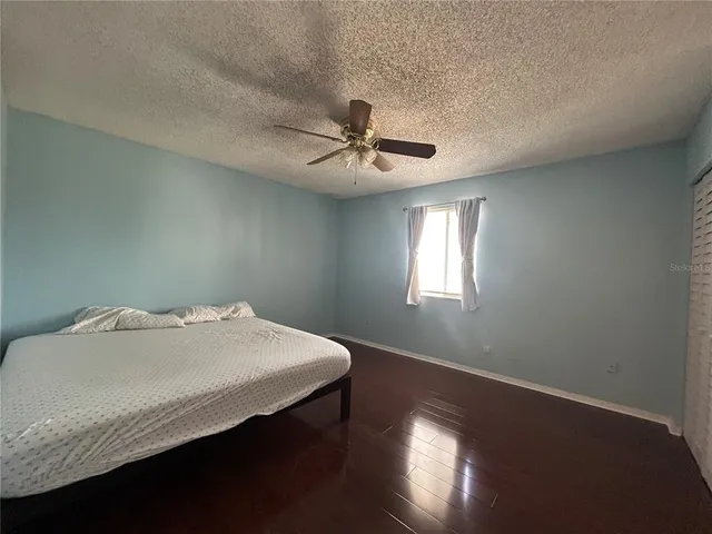 a bedroom with a bed and a chandelier fan