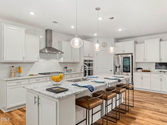 a kitchen with stainless steel appliances granite countertop a stove refrigerator and a wooden cabinets
