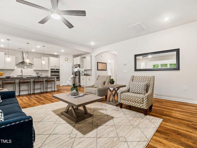 a kitchen with a dining table chairs stove refrigerator and cabinets