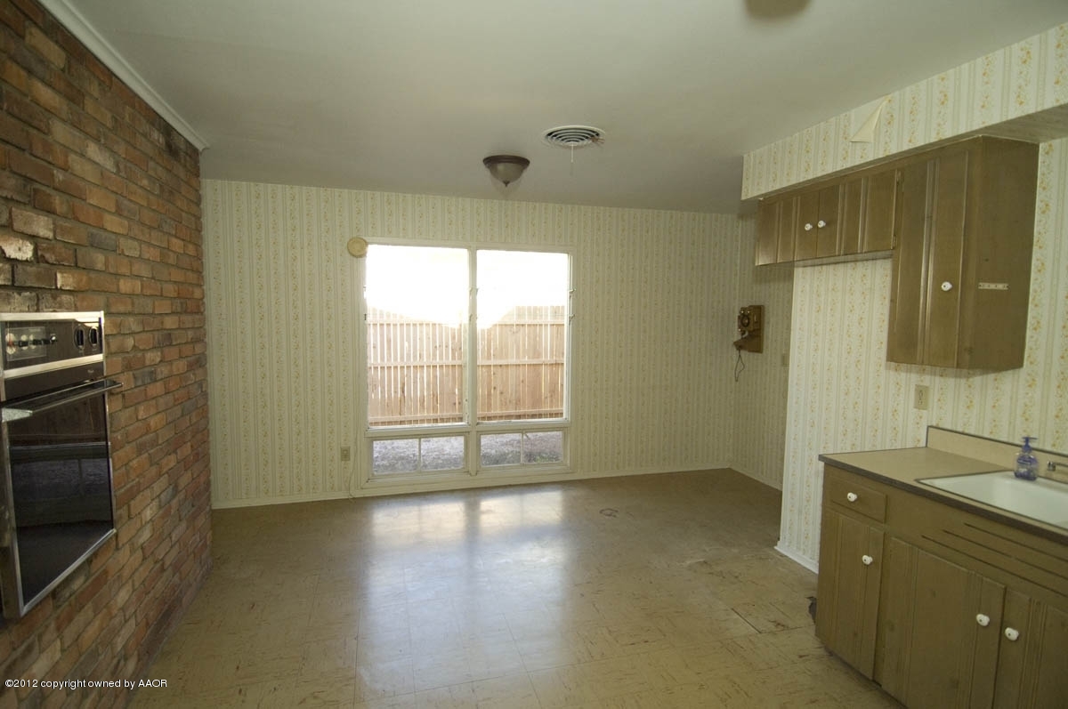1020 South Rusk Street Amarillo, TX 79102 - Photo 13 of 32 a view of an empty room with a fireplace and a window