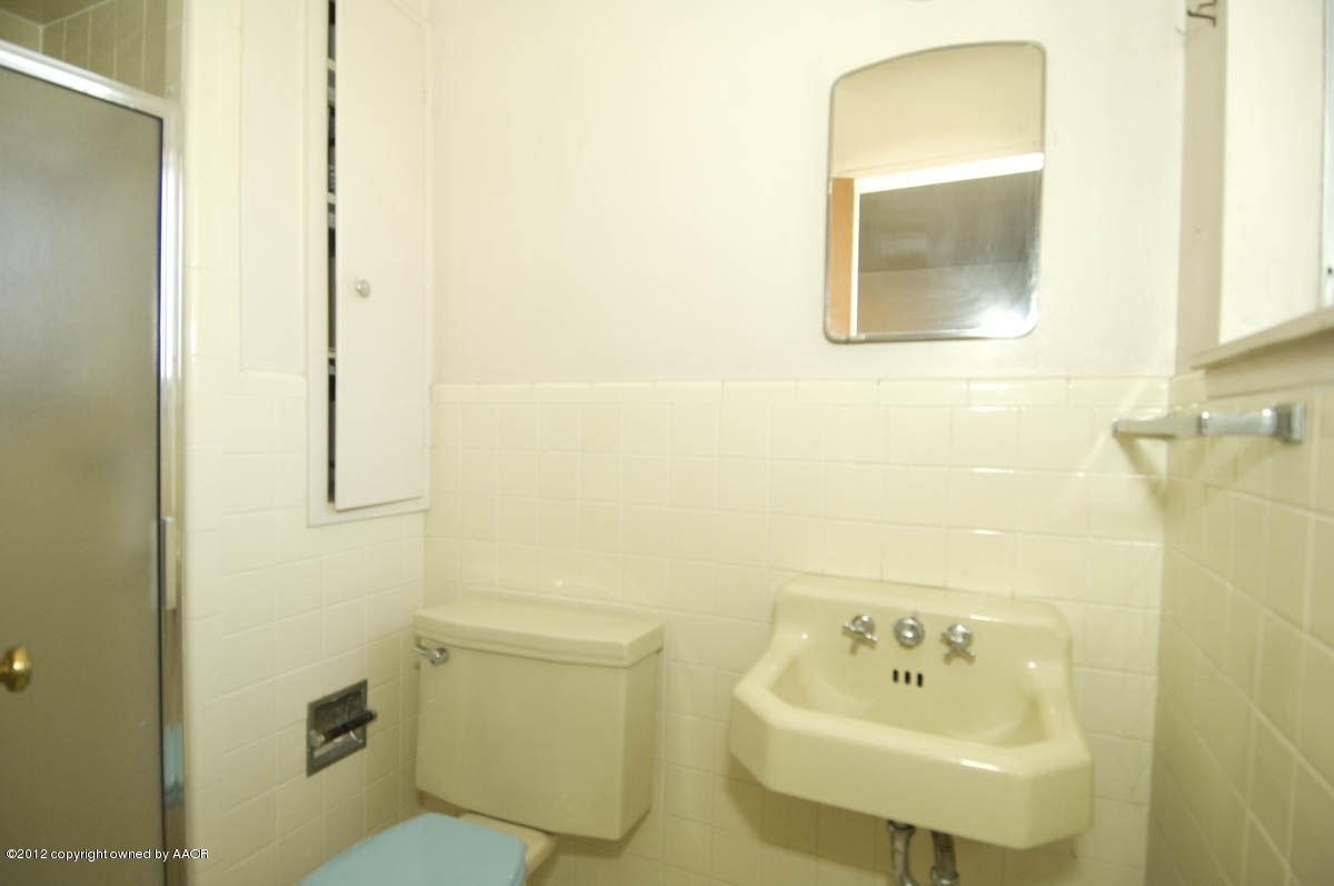 1020 South Rusk Street Amarillo, TX 79102 - Photo 16 of 32 a bathroom with a sink a toilet and mirror