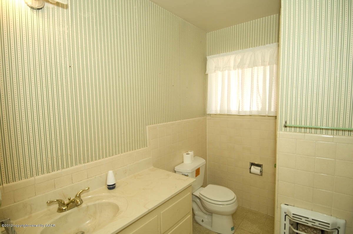 1020 South Rusk Street Amarillo, TX 79102 - Photo 20 of 32 a bathroom with a sink a toilet and a mirror