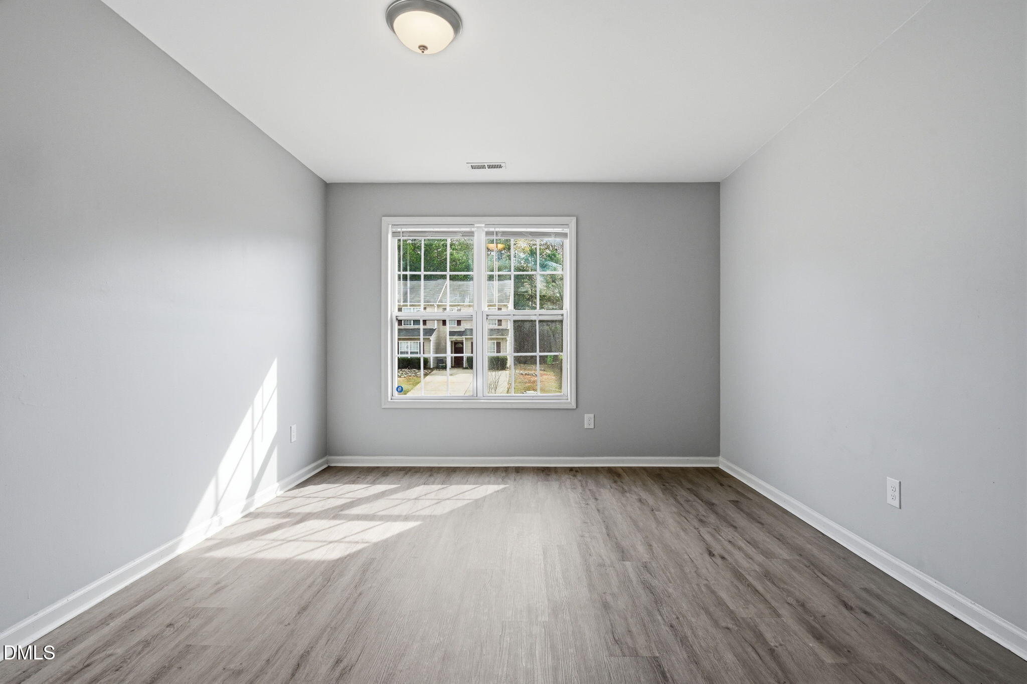 2826 Herndon Village Way Raleigh, NC 27610 - Photo 11 of 32 an empty room with wooden floor and windows