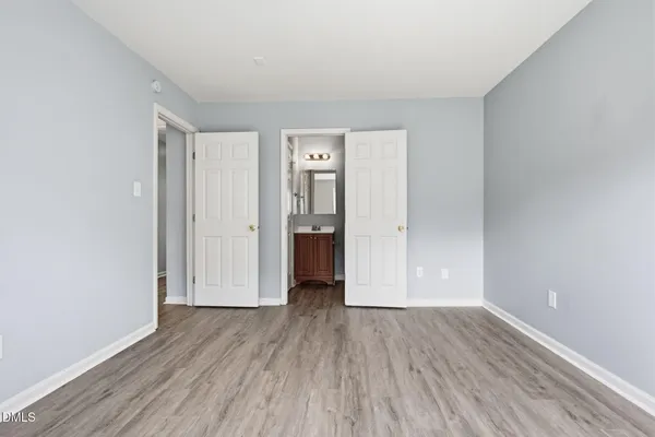 a view of a room with wooden floor and white doors