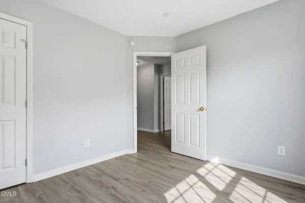 a view of an empty room with wooden floor