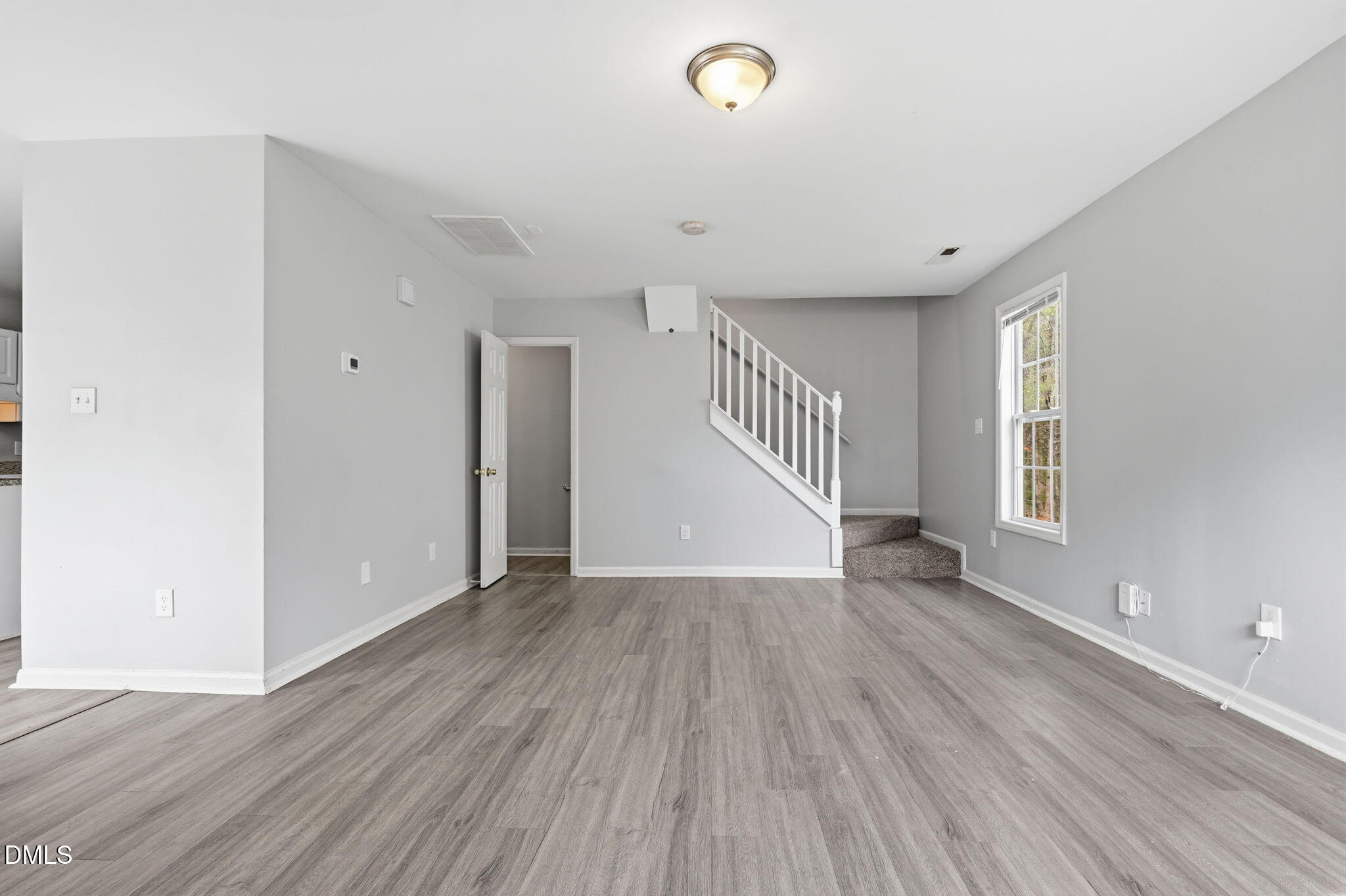 2826 Herndon Village Way Raleigh, NC 27610 - Photo 5 of 32 a view of an empty room with wooden floor and a window