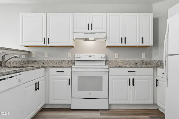 a kitchen with white cabinets and white appliances