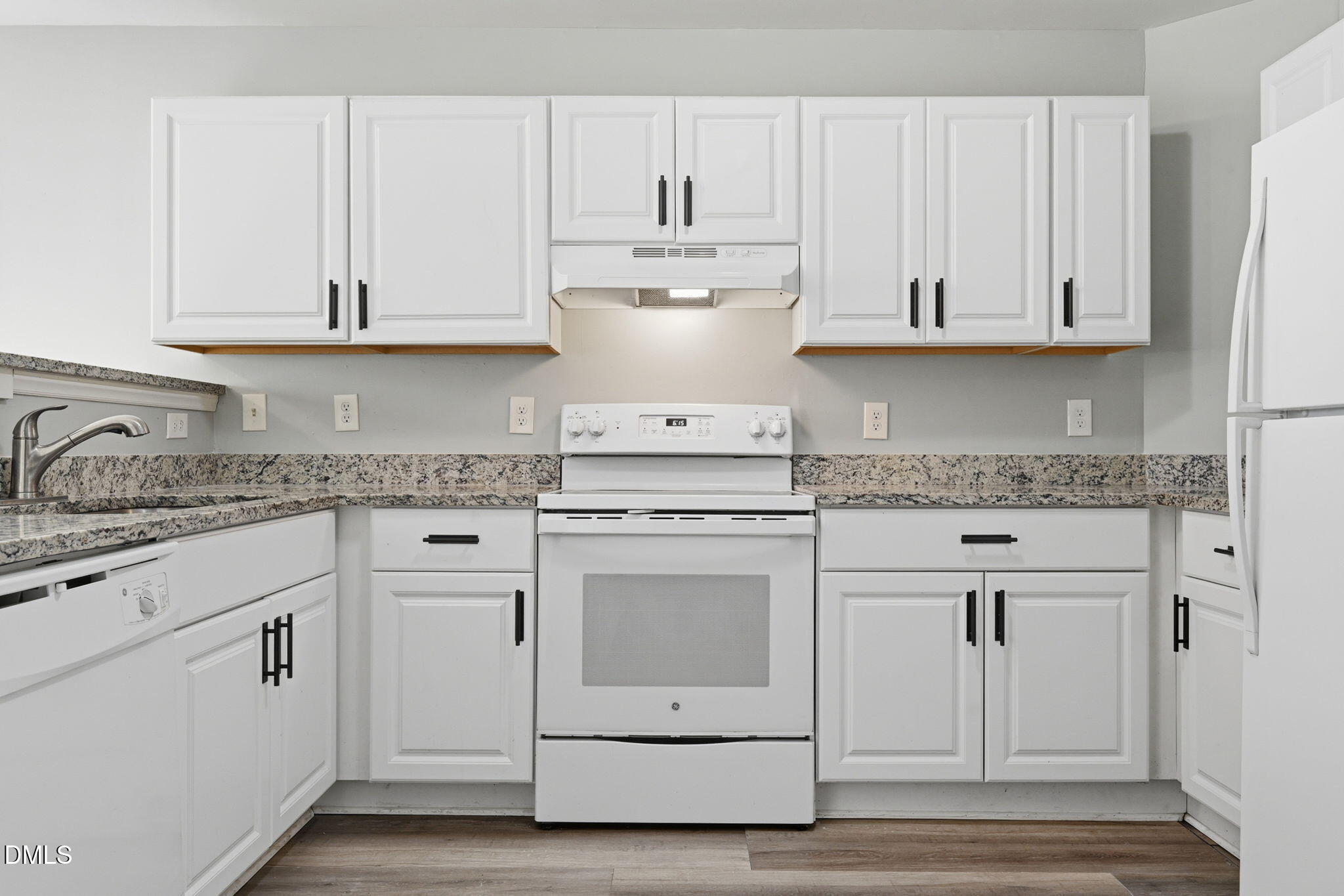 2826 Herndon Village Way Raleigh, NC 27610 - Photo 7 of 32 a kitchen with white cabinets and white appliances