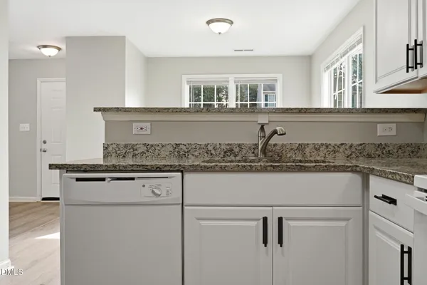 a kitchen with granite countertop a sink and a stove