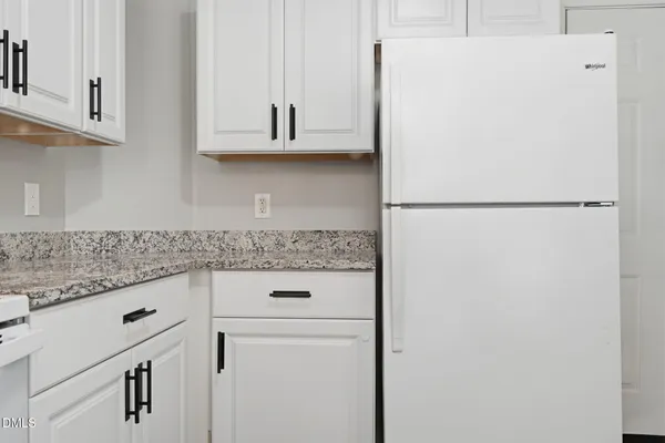 a kitchen with white cabinets and white appliances