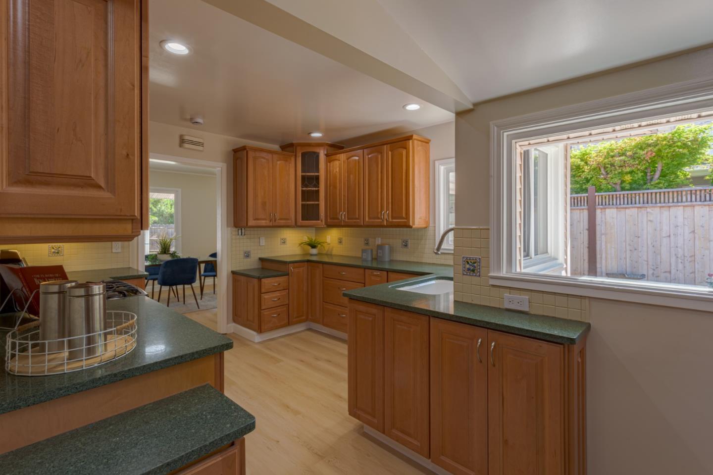 260 Oakhurst Place Menlo Park, CA 94025 - Photo 9 of 23 a kitchen with kitchen island granite countertop a sink stove and cabinets