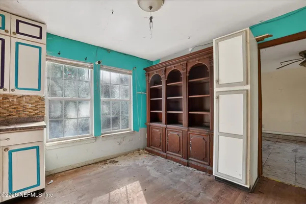 a view of an empty room with a fireplace and windows