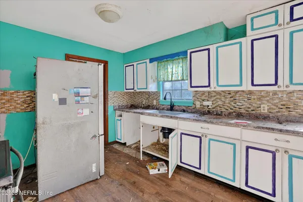 a kitchen with a refrigerator a sink and cabinets