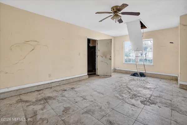 a view of a livingroom with a ceiling fan and window