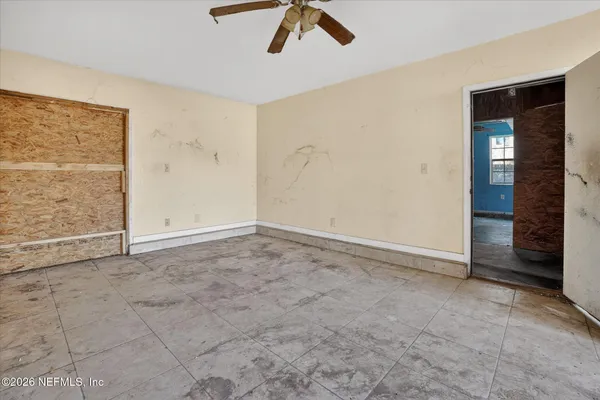 an empty room with closet and fan