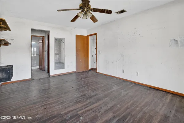 a view of empty room with wooden floor
