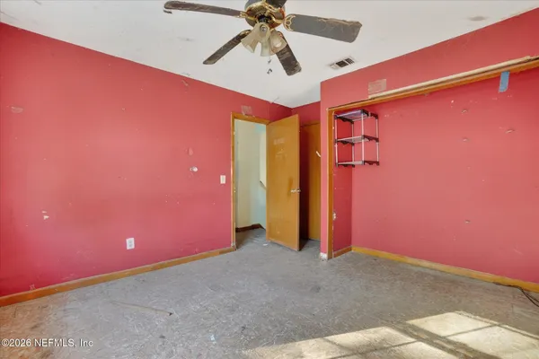 a view of a room with a ceiling fan and window