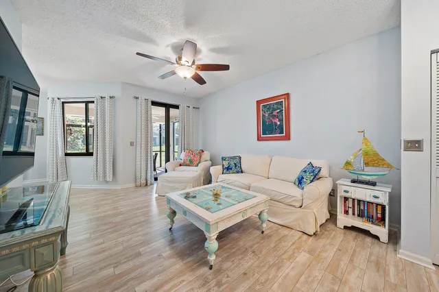 a living room with furniture a two lamps and a wooden floor